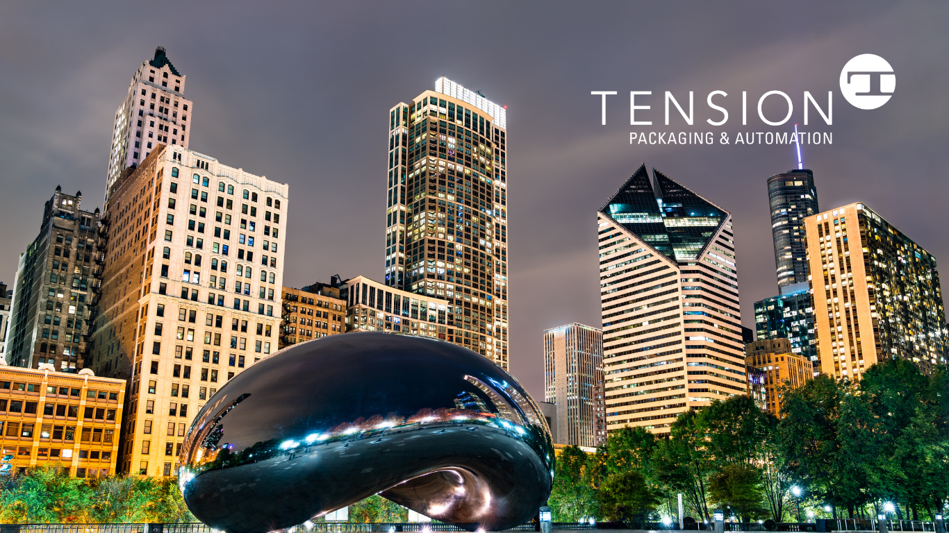 Cloud Gate sculpture in Chicago’s Millennium Park with illuminated city skyscrapers at night. The Tension Packaging & Automation logo and text are displayed in the top right corner.